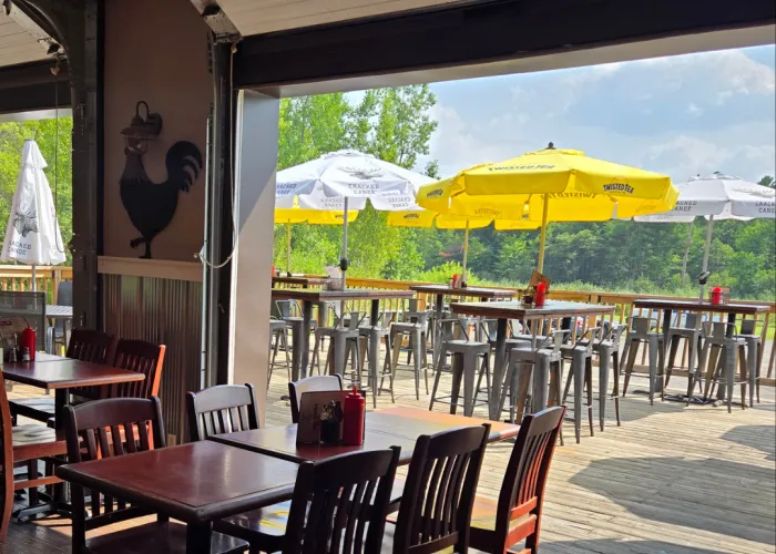 indoor seating with garage door opening onto a patio on a sunny day