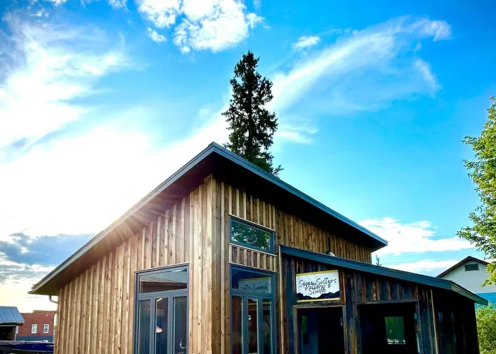 Pottery studio, wood board and batten siding, blue sky, clouds above