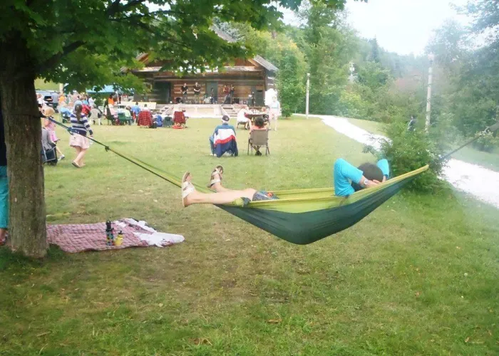 Person in hammock, people on lawn watching band perform in bandshell