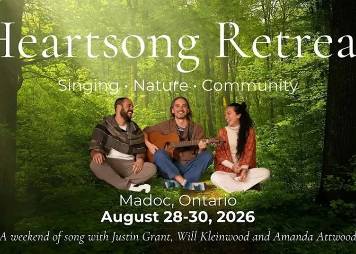 Background is a forest scene with dense, green trees, in foreground, three people sitting cross-legged together, one holding guitar, event information
